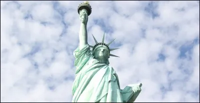 In which hand does Lady Liberty hold a stone tablet?