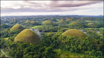 Which island is known for its chocolate-colored hills during the dry season?