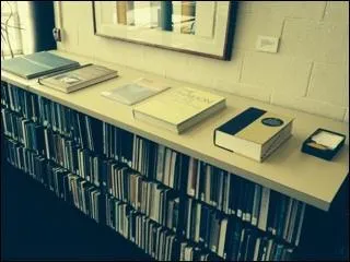 The Road Atlas and Dictionary are located on top of the the short shelf unit (by the Emergency Exit door).