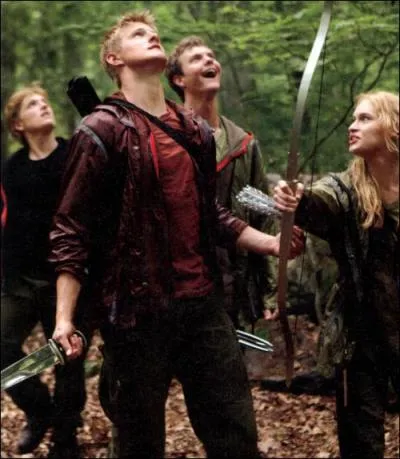 What does Peeta do that surprises Katniss on their first night in the arena?