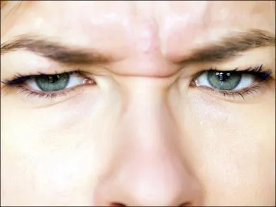 What tightened eyebrows of this woman suggests?