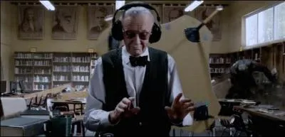 Stan Lee looks after a library while Spider-Man fights behind him.